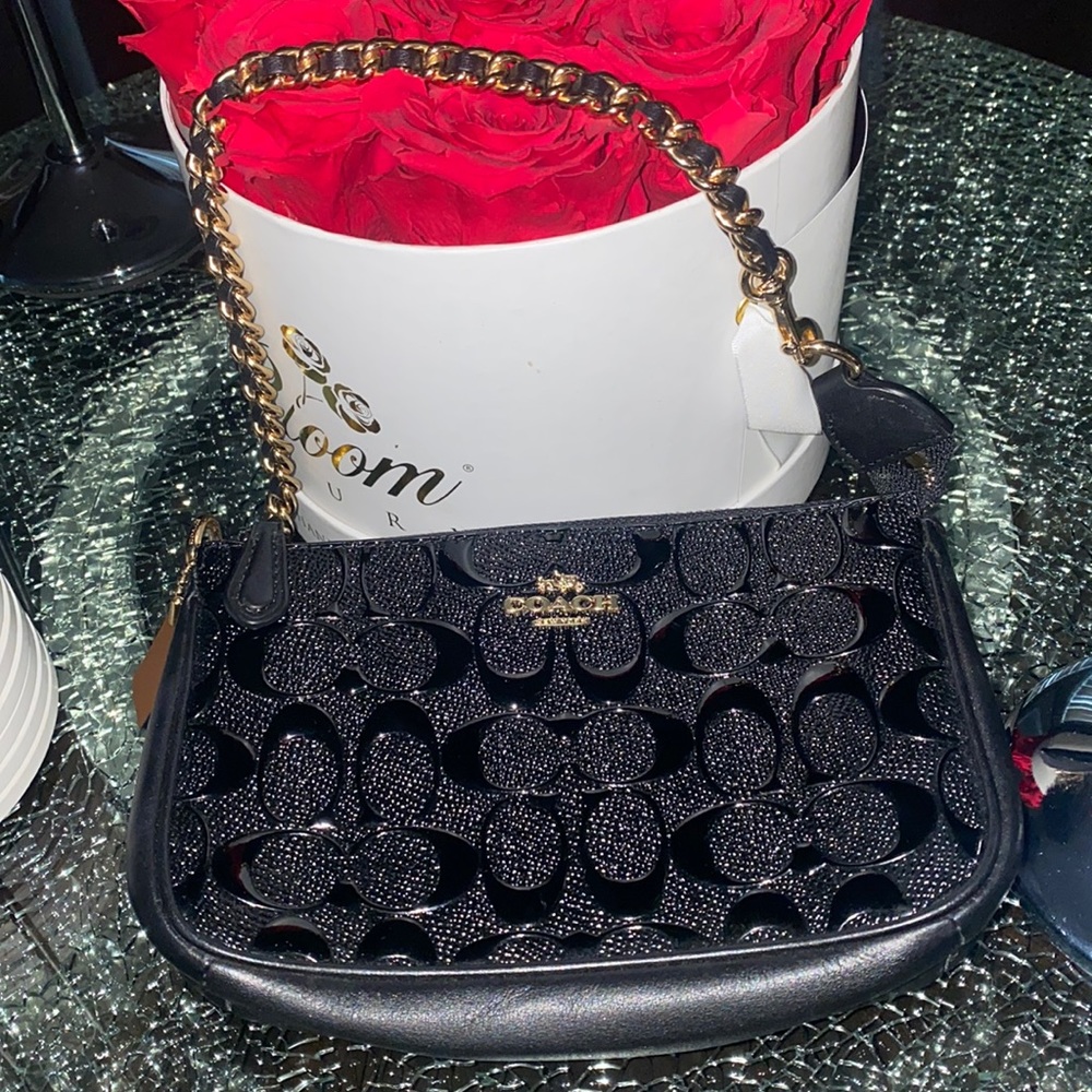 Womens coach black embossed  wristlet with chain.